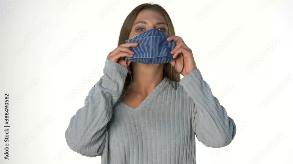a young beautiful woman puts on a protective mask on a white background a young beautiful woman puts on a protective mask on a white background