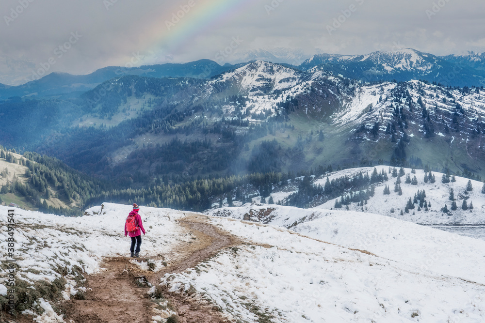 active woman hiking in the first autumnal snow in the Allgau Alps near Oberstaufen, Bavaria, Germany
