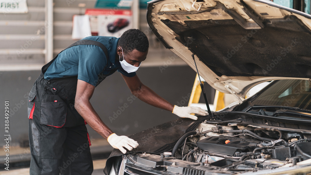 Auto mechanic working in garage, car repair services