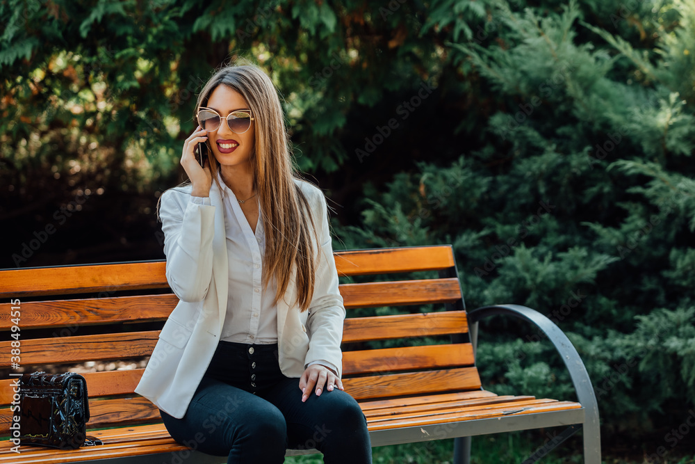 Beautiful businesswoman speaking on a phone outdoor. Beautiful businesswoman speaking on a phone outdoor.