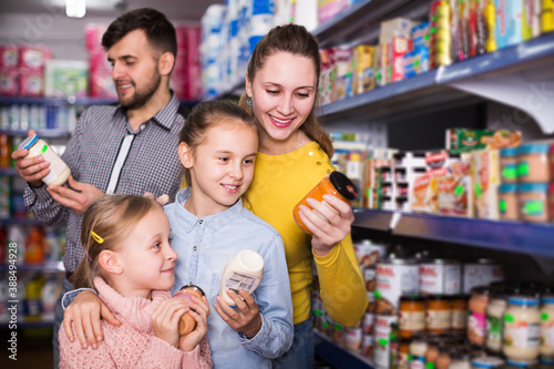 positive family of four shopping together in grocery store