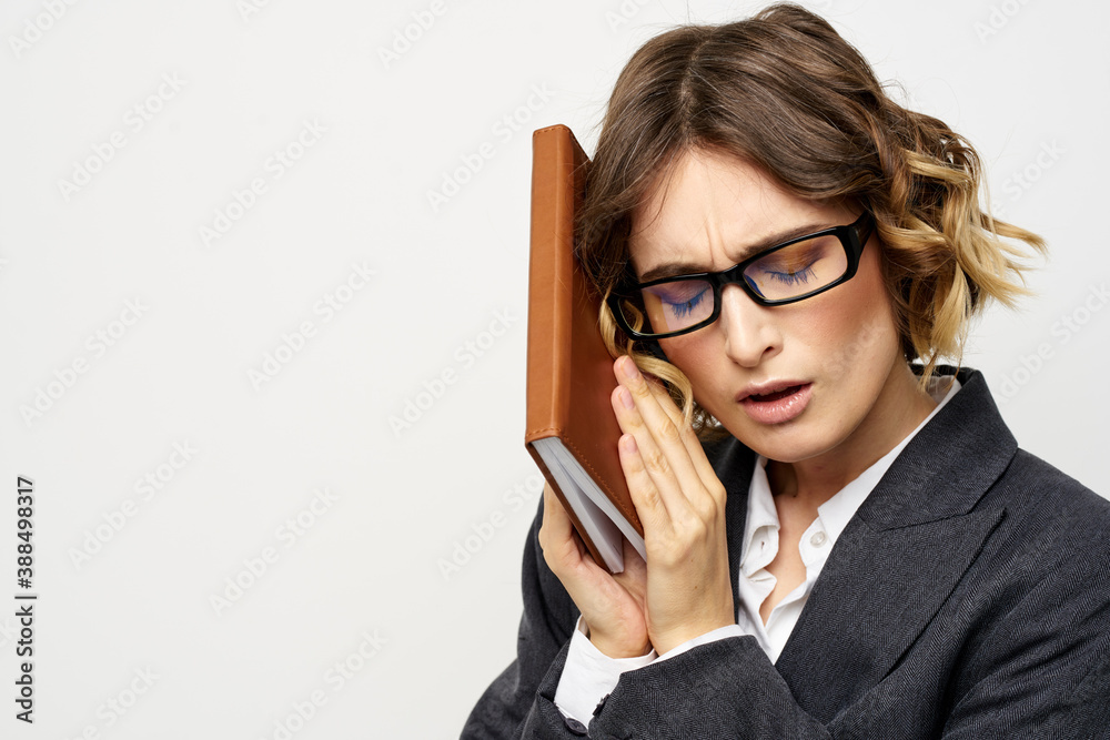 Business woman with notepad and glasses work light background cropped view of suit model.