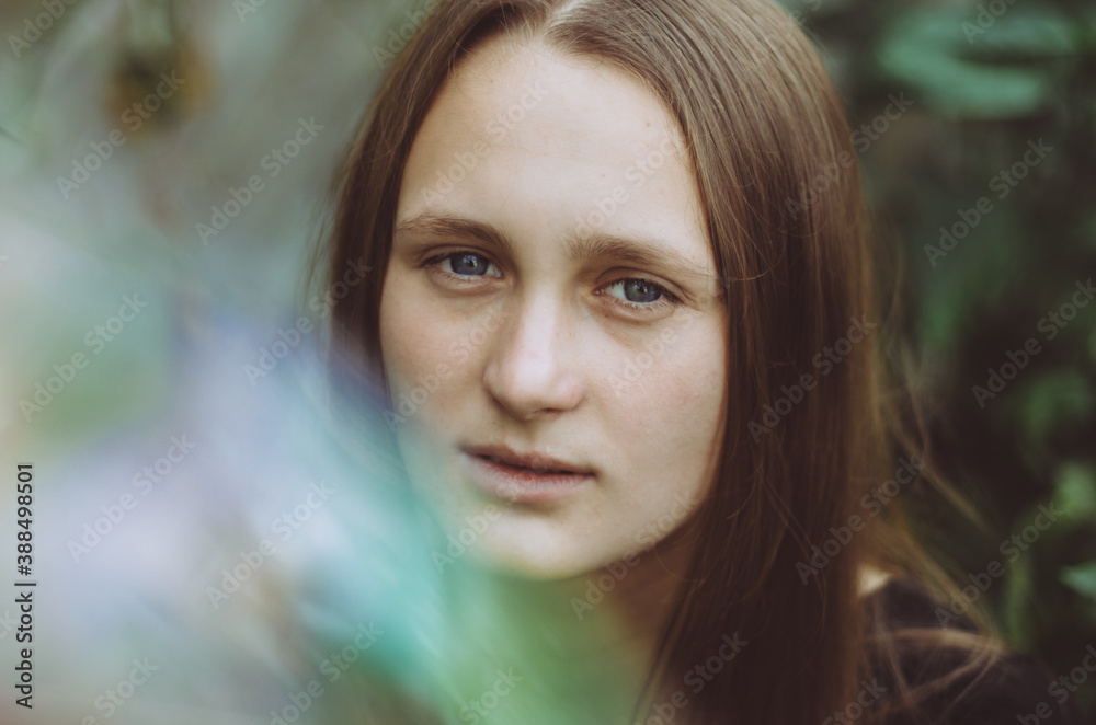Front view profile headshot of a young caucasian woman with neutral face expression, with light effects on left corner Front view profile headshot of a young caucasian woman with neutral face expression, with light effects on left corner