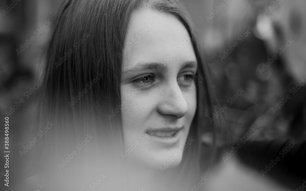 Black and white portrait of a young, caucasian woman looking to the side smiling Black and white portrait of a young, caucasian woman looking to the side smiling