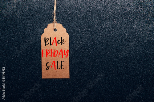 Words Black Friday Sale written on tag. Brown Kraft Paper Gift Tag on black paper as background, zero waste and sustainable living, shopping sale concept