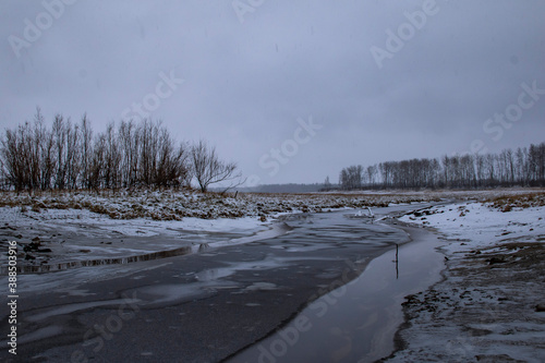 Landscape - the beginning of winter in Siberia. Snowy field, yellow grass, first snow and frozen river. © Илья Юрукин