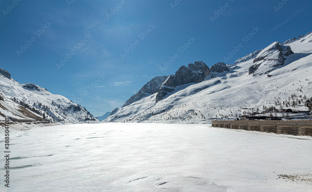 Fototapeta premium frozen lake of fedaia with dam, Italian alps