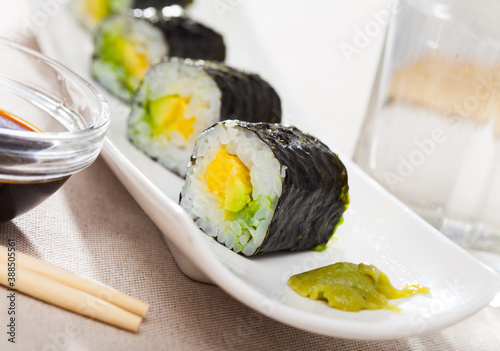 Tasty Maki roll with avocado served on plate with sauce