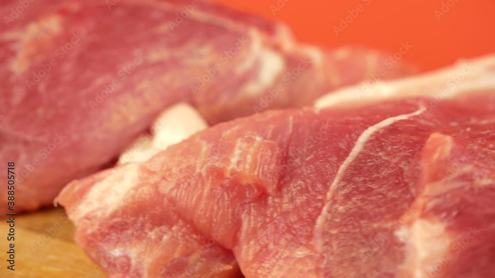 Close-up of pieces of fatty raw pork meat on a rotating board. Butcher shop. Raw meat is red. Fresh meat tenderloin. Selective focus, shallow depth of field Close-up of pieces of fatty raw pork meat on a rotating board. Butcher shop. Raw meat is red. Fresh meat tenderloin. Selective focus, shallow depth of field