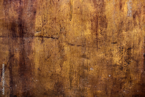golden metal rough surface with irregular yellow and dark brown tones - worn steampunk background with dirty texture and scratches for an epic wallpaper of a goldmine