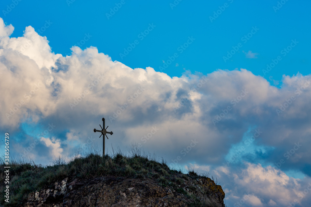 Selective focus on metallic cross on small rocky hill, Southern Bulgaria, cloudy autumn day. Moody dark silhouettes picture. Location near the shore of Ahtopol, Black Sea Selective focus on metallic cross on small rocky hill, Southern Bulgaria, cloudy autumn day. Moody dark silhouettes picture. Location near the shore of Ahtopol, Black Sea