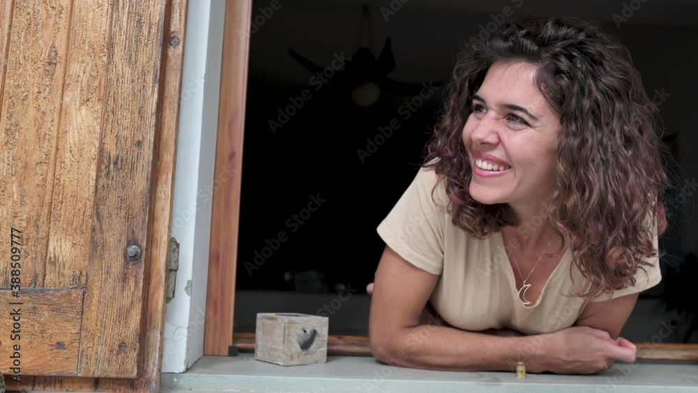 Young woman looking out the window and talking with some neighbour. Sharing, friendly concept Young woman looking out the window and talking with some neighbour. Sharing, friendly concept