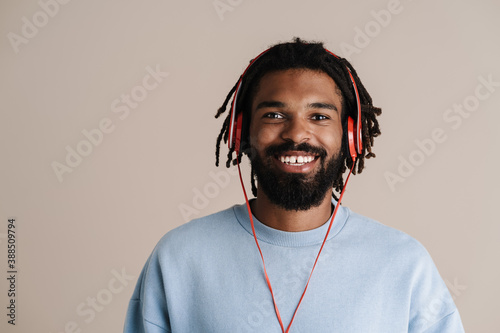 Tableau sur toile Cheerful african american guy in headphones smiling at camera