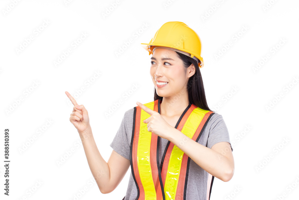 Attractive beautiful young asian construction female worker in yellow helmet and reflective vest pointing finger at copy space with confident isolated on white background. Attractive beautiful young asian construction female worker in yellow helmet and reflective vest pointing finger at copy space with confident isolated on white background.