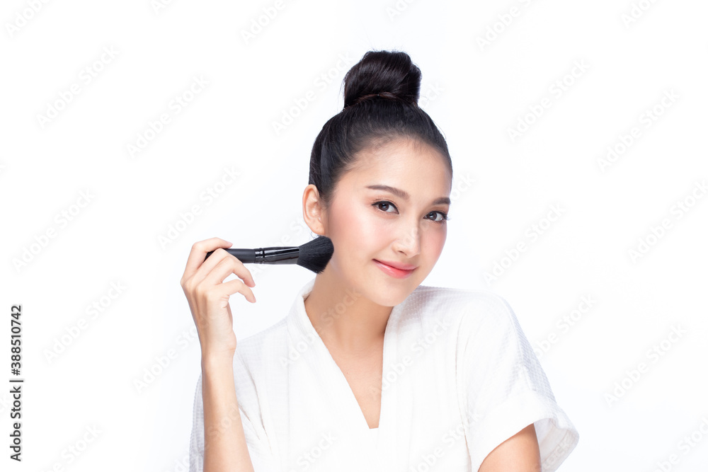 Closeup portrait of beautiful happy young girl holding brush near face isolated on white background. Beauty and cosmetics concept. Closeup portrait of beautiful happy young girl holding brush near face isolated on white background. Beauty and cosmetics concept.