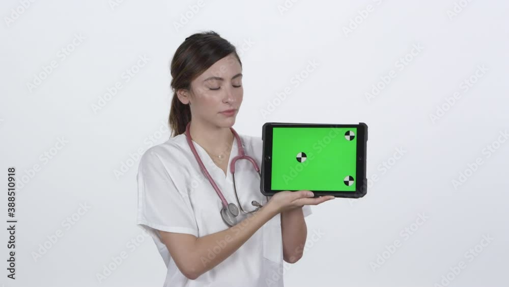 Medical personnel holding and looking at tablet with serious face with green screen for keying. Medical personnel holding and looking at tablet with serious face with green screen for keying.