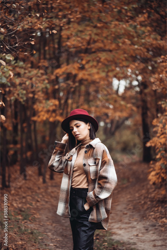 Beautiful elegant woman standing in a park in autumn © alipko