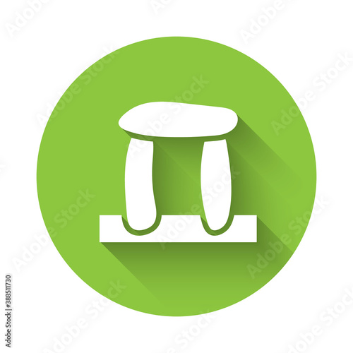 White Stonehenge icon isolated with long shadow. Green circle button. Vector.
