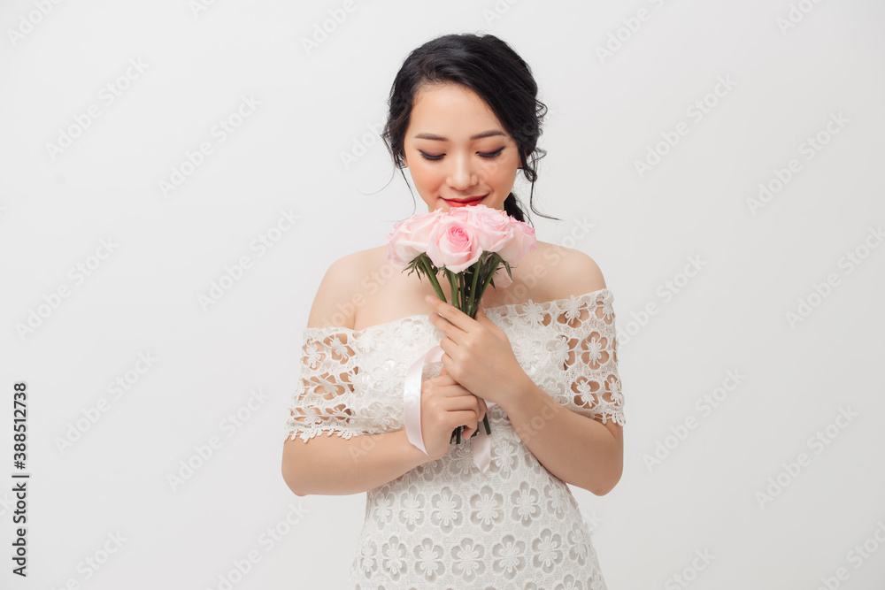 Happy Asian young attractive woman holding flower bouquet and wearing white background. Happy Asian young attractive woman holding flower bouquet and wearing white background.