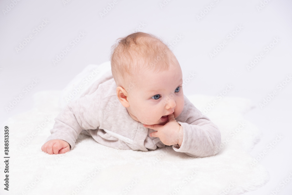 Charming baby is lying on the floor and sucking one’s small fingers Charming baby is lying on the floor and sucking one’s small fingers