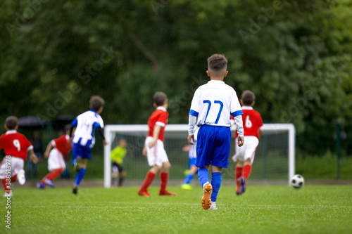 Soccer Kids Playing Game. Happy Children Kicking Football Tournament Match. Players in Two Teams in Blue and Red Jersey Sportswear