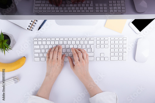 top view of female hands typing on computer keyboard near stationery, work concept 