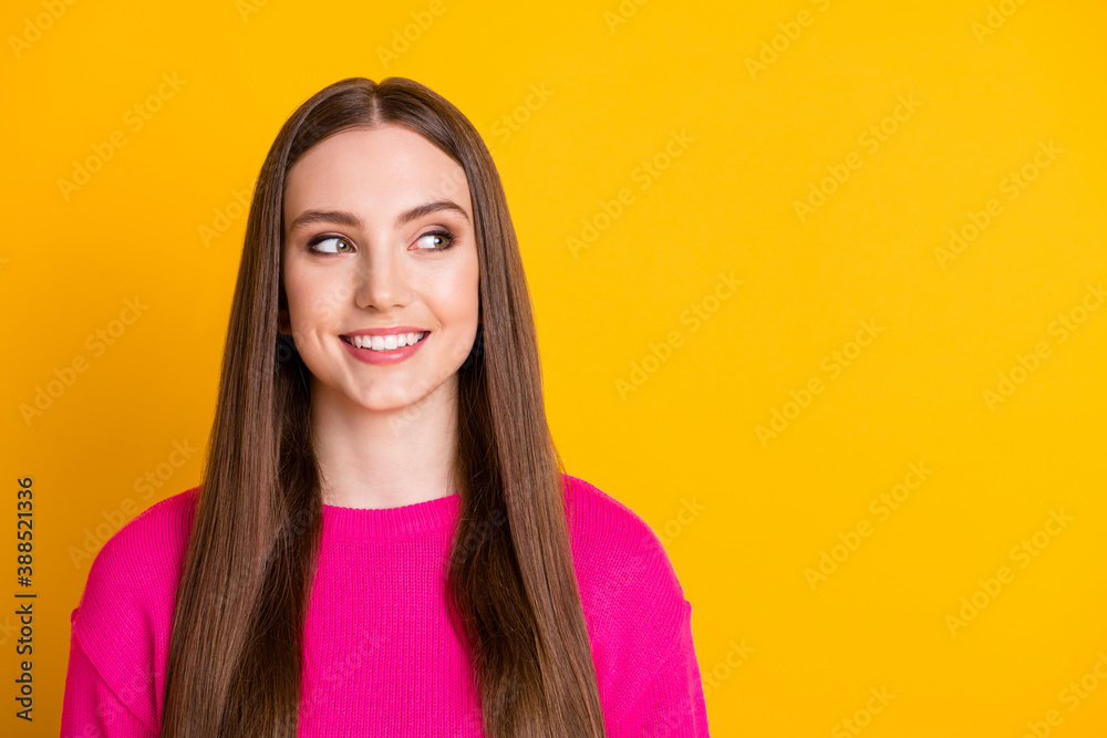 Photo of young cute girl shiny smile look empty space wear pink sweater isolated yellow color background Photo of young cute girl shiny smile look empty space wear pink sweater isolated yellow color background