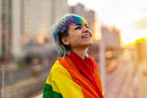 Portrait of a gender fluid person wearing rainbow flag
 photo