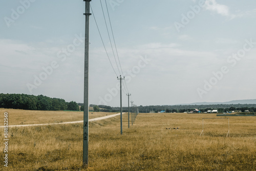 electric towers in the middle of a field on a sunny day in summer