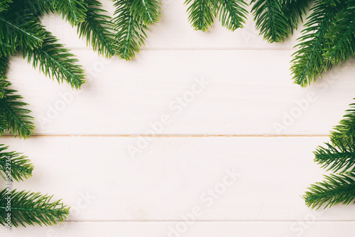 Top view of fir tree branches on wooden background. New Year time concept with empty space for your design