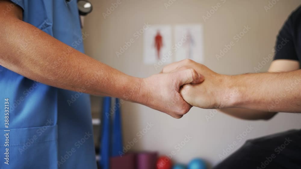 Nurse squeezing hands of patient while standing in clinic. Nurse squeezing hands of patient while standing in clinic.