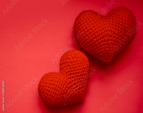 two Red knitted hearts isolated on blue  background. happy Valentines Day idea. photo