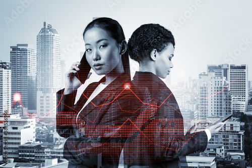 Two young astonishing businesswoman in suits working on forecasting trading corporate strategy at fund. Forex chart. Bangkok on background. Double exposure. © VideoFlow