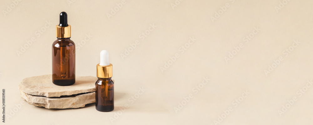 Two brown bottles of cosmetics on a natural beige background. Stone podium. Front view. Two brown bottles of cosmetics on a natural beige background. Stone podium. Front view.