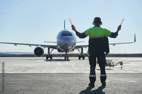 The runway traffic controller uses gestures and sticks to help the aircraft choose the correct trajectory around the airfield photo