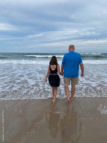 Father and daughter walking on the beach
