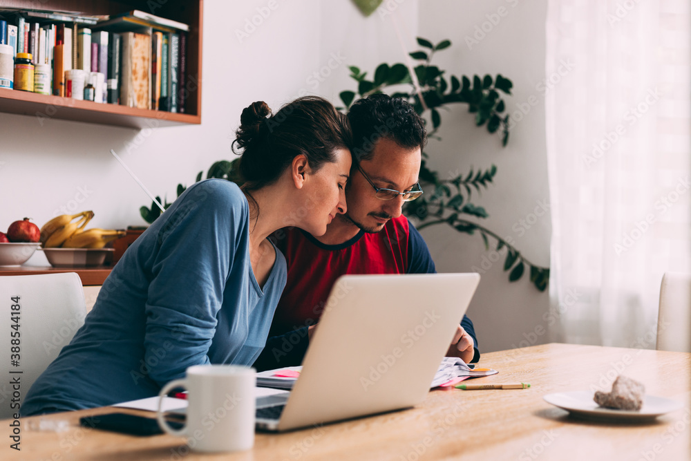 Happy looking couple work together from home, using laptop Happy looking couple work together from home, using laptop