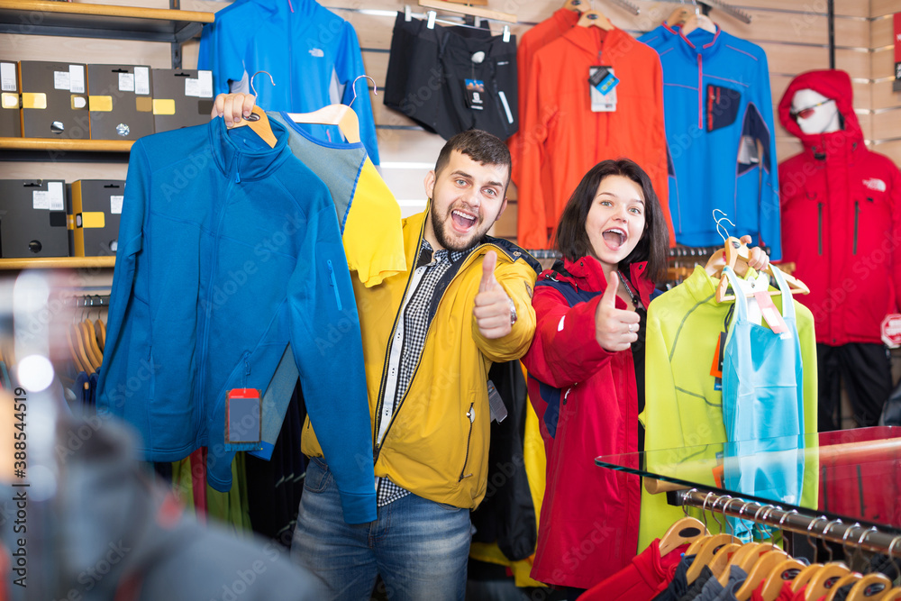 Young couple enjoying new sportswear in sports clothes store