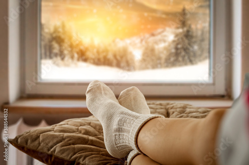 Woman legs with socks and winter window 