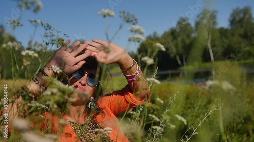 portrait of a happy smiling woman in sunglasses in a summer field. nature, summer vacation concept, vacations and people photo