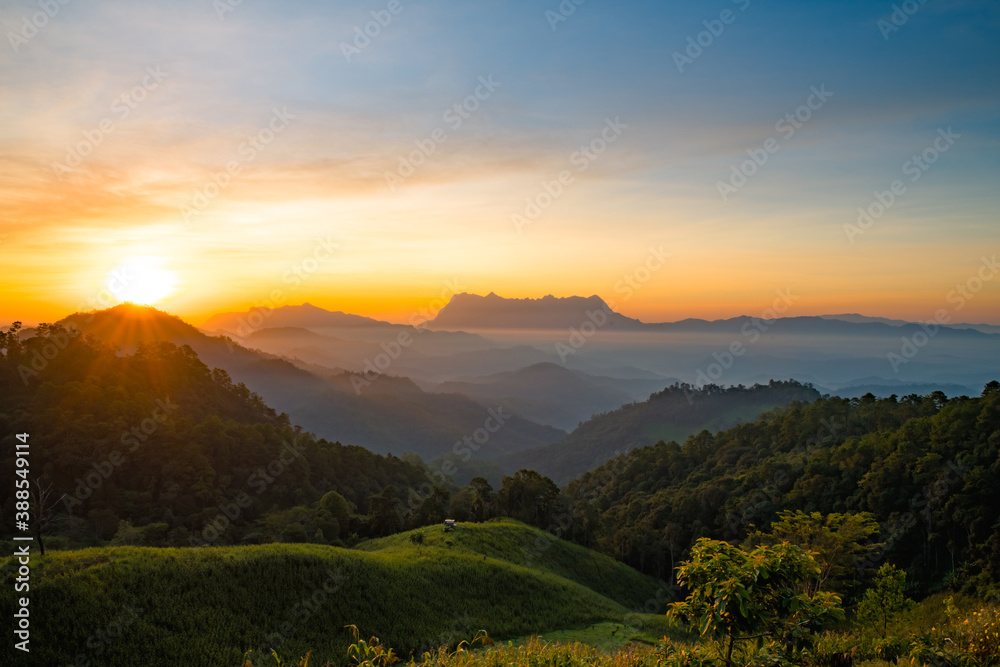 Scenery of the sky gradient from blue to orange sunrise over the valley at Doi Luang, Chiang Dao, Chiang Mai, Thailand.