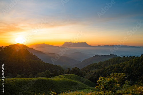 Scenery of the sky gradient from blue to orange sunrise over the valley at Doi Luang, Chiang Dao, Chiang Mai, Thailand.
