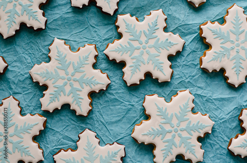 homemade gingerbread cookies in the form of snowflakes. Flat lay composition with snowflakes and cookies on blue background.