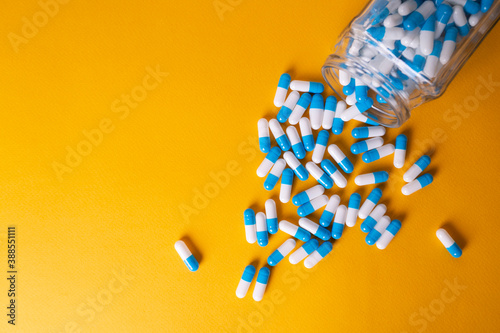 white and blue pills on yellow background