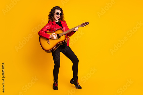 Full length body size view of pretty cool cheerful popular wavy-haired girl playing guitar isolated bright yellow color background