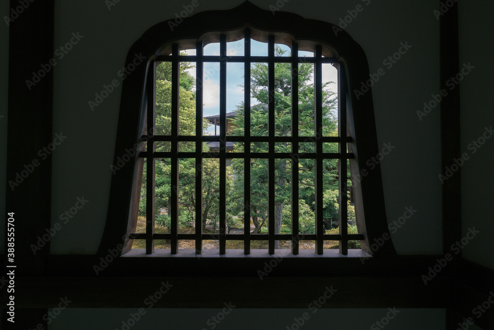 Looking at the architecture and gardens of Tenryuji Temple through an old wood window