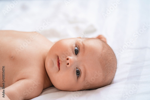 cute baby lying on bed on white blanket against background children's room