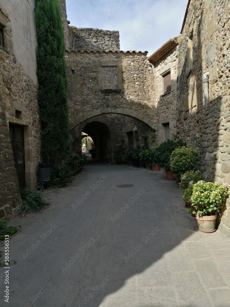 medieval village. Stone walls with an arch in the background. Monells