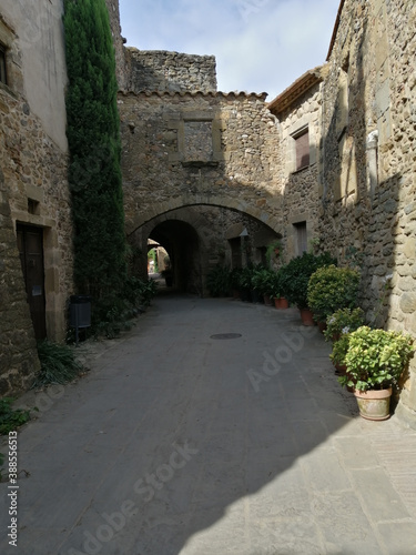 medieval village. Stone walls with an arch in the background. Monells