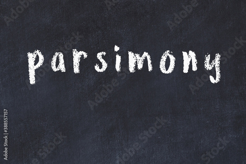 Black chalkboard with inscription parsimony on in